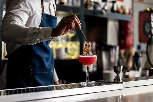 Unrecognizable professional young bartender working