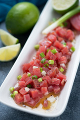 Close-up of a white plate with tuna fillet ceviche, selective focus, studio shot