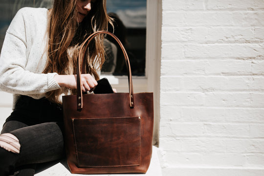 Woman putting phone in bag
