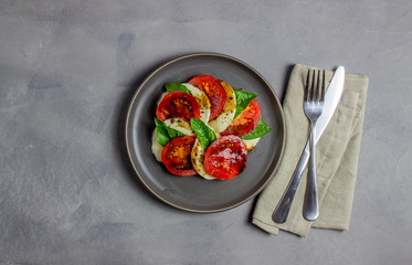 Italian caprese salad with mozzarella and tomatoes. Concrete background. Healthy food.