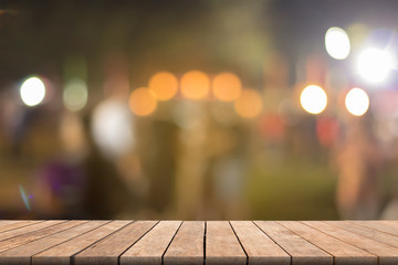 Blurred wooden table in front blurred night street market with bokeh abstract background, copy...