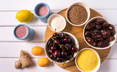 Superfoods in Bowls , fresh fruits, ginger  and berry smoothie over white wooden Background.