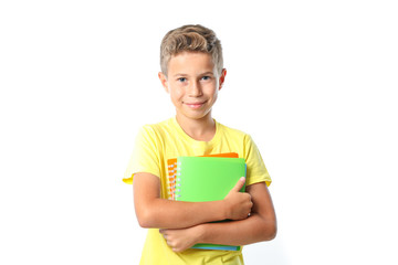 Boy in yellow t-shirt with copybooks isolated on white background