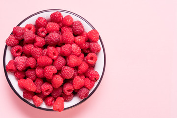 Red fresh ripe raspberry in a bowl. Summer concept.