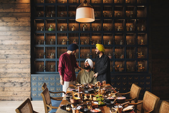 Smiling father and sons in restaurant - Powered by Adobe