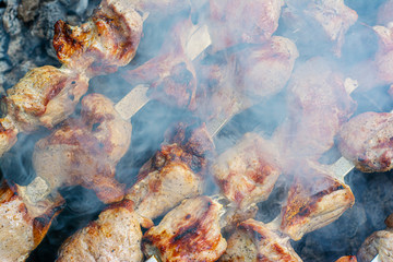 Obraz na płótnie Canvas Pork roasted over the coals. Closeup of a barbecue with smoke in the foreground.