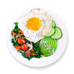 Healthy delicious keto paleo breakfast: fried egg with sauteed vegetables, avocado and cucumber on white plate. White background. Top view.