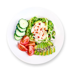Healthy delicious keto paleo breakfast: egg in a hole in zucchini noodles with avocado, cucumber and tomato. White background. Top view.