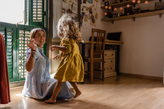 Woman with girl on floor at home