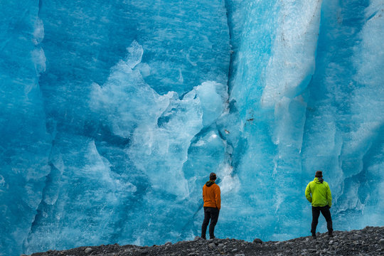 Rear view of men standing against glacier