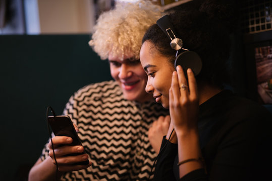 Woman with headphones listening to music on mobil phone