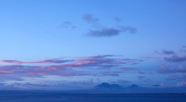 Fototapeta Vague volcano in the background of the sunset sky