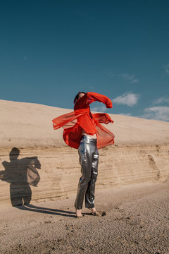 Anonymous model in strange clothes dancing under sun