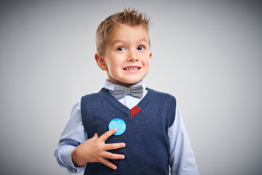 Portrait of a 4 year old boy posing over white with badge
