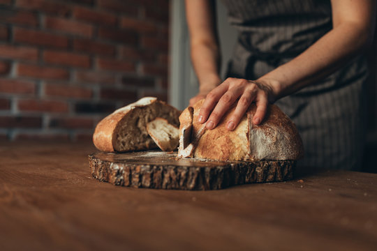 Midsection of baker slicing bread