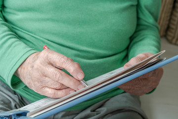 closeup wrinkled hand of a senior person writing something