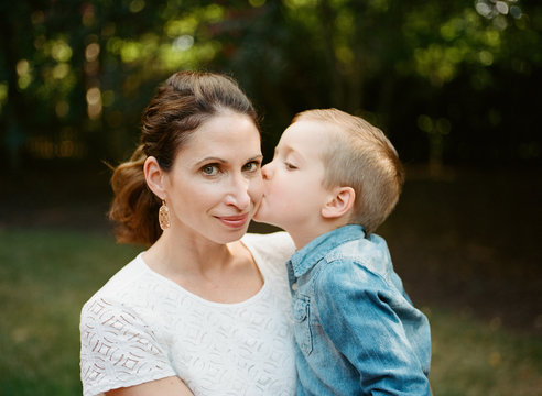 Young son giving his mother a kiss on the cheek