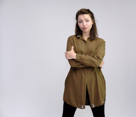 A portrait above the knee of a pretty adult brunette girl in a dress on a white background. Standing directly in front of the camera, showing different poses and emotions.