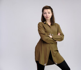 A portrait above the knee of a pretty adult brunette girl in a dress on a white background. Standing directly in front of the camera, showing different poses and emotions.