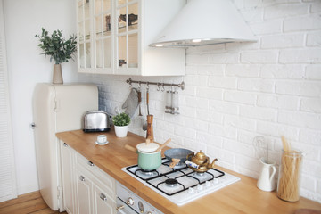 Interior of modern sunny kitchen in a Scandinavian-style apartment. Kitchen furniture, dishes, spices