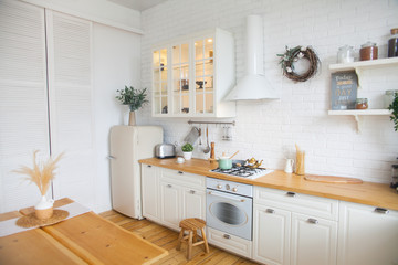 Interior of modern sunny kitchen in a Scandinavian-style apartment. Kitchen furniture, dishes, spices