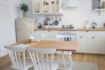 Interior of modern sunny kitchen in a Scandinavian-style apartment. Kitchen furniture, dishes, spices