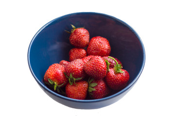 isolated on white background blue bowl with ripe red strawberries close-up