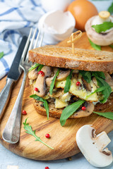 Toasted bread sandwich with mushrooms and scrambled eggs.