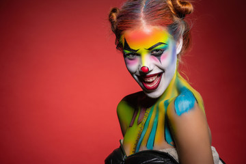 Beautiful young lady with a face painting clown.