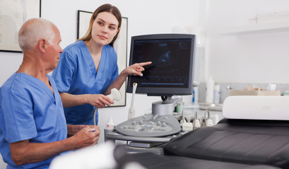 Fototapeta na wymiar elderly doctor and nurse in cabinet of ultrasound test