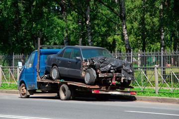 a car crashed in an accident and loaded onto a tow truck for transportation to repair