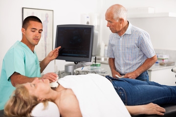 Obraz premium Professional sonographer explaining results of ultrasound diagnostic to female patient and her husband