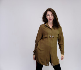 A portrait above the knee of a pretty adult brunette girl in a dress on a white background. Standing directly in front of the camera, showing different poses and emotions.