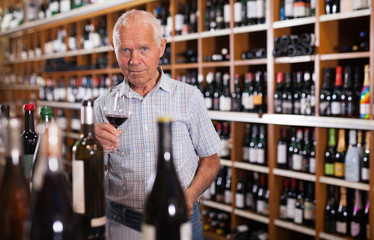Senior male tasting wines in winery