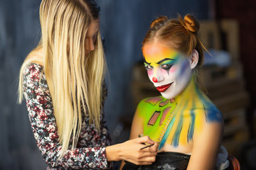 The artist applies body art to a lovely woman.