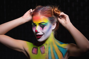 Alluring lady with a face painting clown.