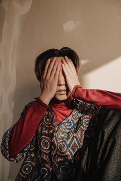 Young man covering eyes with hands
