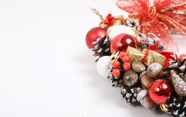 Preparation for greetings on New Year and Christmas with a fragment of Christmas wreath decorated with gifts, cones, acorns, berries, apples.