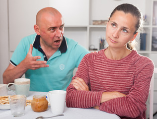 Fototapeta na wymiar Husband displeased with his wife. Family quarrel in the kitchen