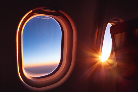 Sunrise on an aircraft, viewed through two windows