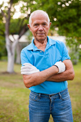 Naklejka na ściany i meble Elderly gardener posing in his garden