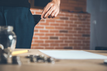 .man hand empty pocket with coins on desk