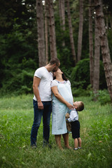 Fototapeta premium Pregnant young woman with her family in nature