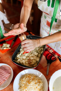 Two women with their young daughters cooking at home