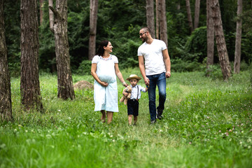 Fototapeta premium Pregnant young woman with her family in nature