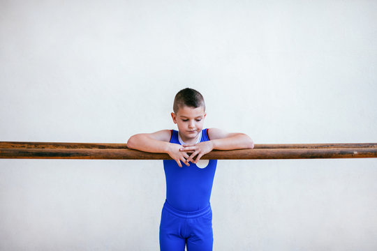 Boy leaning on parallel bars