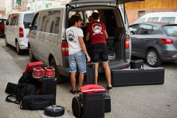 Young musicians uploading the van for traveling