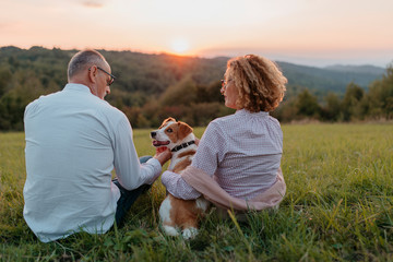 Senior couple with dog watching sunset