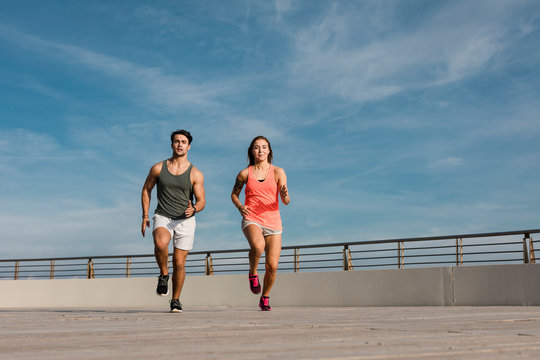 Fit couple jogging in the city - Powered by Adobe