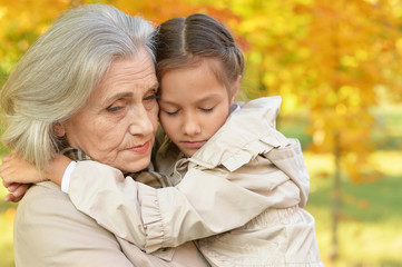 Portrait of sad grandmother and granddaughter in park